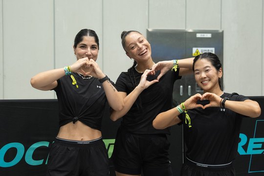 Three athletes in Under Armour kit in front of the REXTREME backdrop, Suwon, August 2026